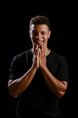 Portrait of young African man smiling with black background