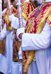 Colorful costumes of the Acolyte Corps in an Andalusian Holy Week procession. - obrazy, fototapety, plakaty