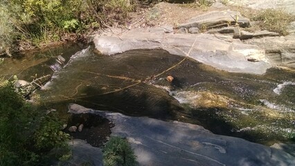 Naklejka na ściany i meble A small stream flowing over the rocks