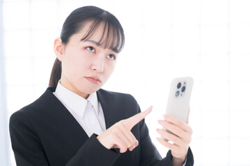 Businesswoman operating a cell phone Troubled or thinking troubled expression