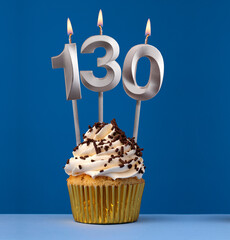 Burning candle number 130 - Birthday card with cupcake on blue Background