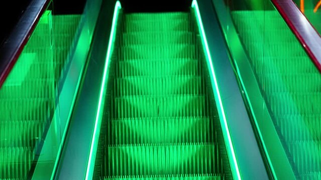 Escalator Steps In Green Light With Red And Yellow Accents