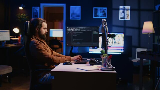 Experienced programmer writing code on computer screen while in office using java programming languages. Developer working on fixing database errors while working from home, camera B