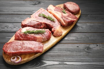 Pieces of raw beef meat on black wooden table