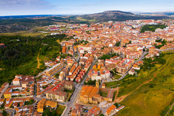 Fototapeta na wymiar Aerial view of small Spanish city of Soria on background of picturesque landscape with river and green hills ..