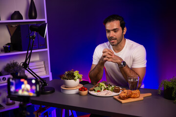 Healthy influencer in host channel presenting fresh vegetables in special dish of salad with brest...