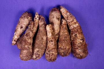 closeup of taro root vegetable, eddo malanga, purple background