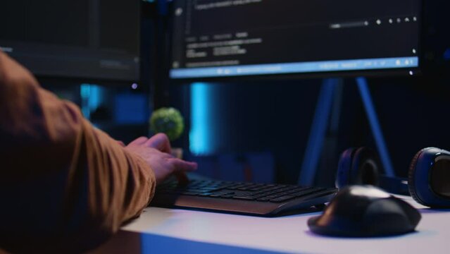 Focus on computer peripheral used by IT admin to type lines of code on desktop PC in apartment. Close up shot of keyboard used by software engineer programming at home, camera B