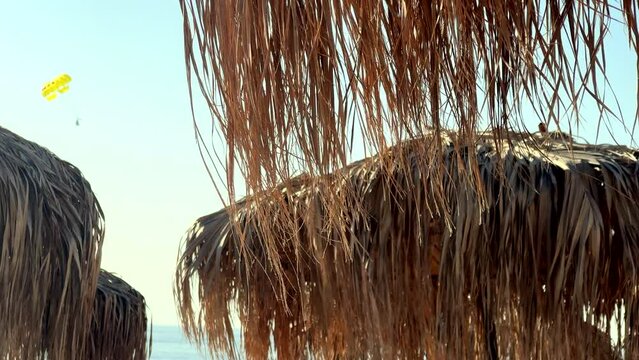 tropical style sunshades and parasailing fun on beach holiday