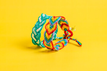 Multicolored woven DIY friendship bracelets handmade of embroidery bright thread with knots...