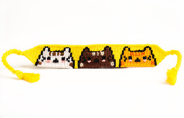 Woven DIY friendship bracelet handmade of embroidery floss with knots. alpha pattern with  cats