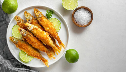 Fried smelt. Crispy breaded smelt fish on white plate, smelt fish, seafood, copy space.