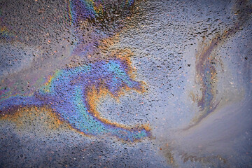 Oil rainbow gasoline spill on asphalt. Rainbow stains of oil and gasoline.