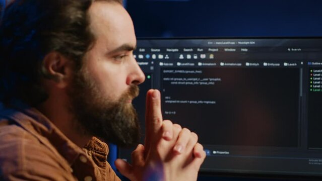 Cheerful software technician feeling satisfied after removing all bugs while coding on computer, close up. Smiling IT expert looking at screen, happy after solving script errors, camera A
