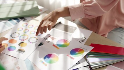 Slow motion hand closeup of two designer brainstorming and choosing color for graphic design working or client asking advise with chromatic consultation at designer agency office. Variegated