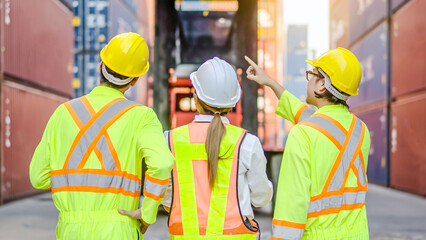Back of group professional dock worker and engineering people walking and taking with their supervisor while record data online with digital connection tablet, background of crane and layer of tank