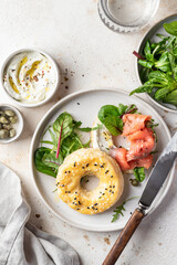 Homemade bagel sandwich with smoked salmon, cream cheese, capers and spinach for healthy breakfast top view