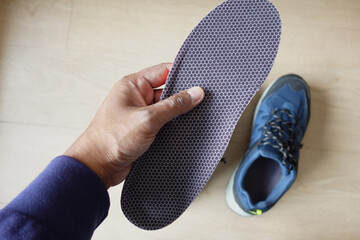 men hand putting Orthopedic insoles in shoes 