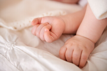 Baby, hands and fingers on bed as closeup for childhood development or nursery sleeping, relax or resting. Kid, wellness and childcare in home for wellbeing nap or dreaming nurture, caring or calm