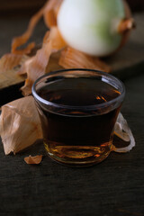 onion skin tea in a glass on a dark wooden table