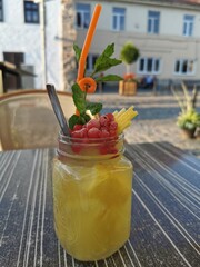A fruity mason jar with a colorful assortment of fruit, complete with a straw for sipping and...