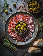 Geschmacksintensive Oliven mit eingelegten Peperoni und würziger Chorizo auf dunkler Granitplatte...