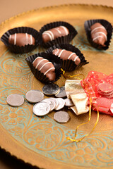 UAE Dirham coins and delicious date chocolates placed in a tray on the occasion of Eid.  Eigy or gift during the festival of Eid..