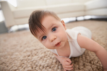 Sweet, cute and portrait of baby on carpet playing for child development in living room at home....