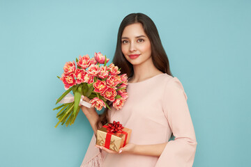Beautiful young woman hold bouquet of tulips flowers and golden gift box, rejoices spring holiday. Women's Day on March 8th