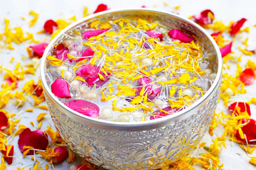 Water with jasmine flower, marigold petal and rose petal in silver bowl. Thai tradition, Songkran...