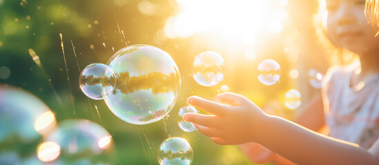 kids playing soap bubbles. summer vacation concept background - obrazy, fototapety, plakaty