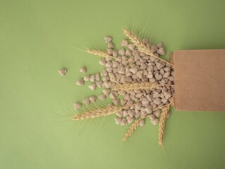 Extruded bran in the shape of a heart is poured out of the package onto a green background....