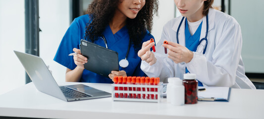 Modern Medical Research Laboratory Portrait of Two African American Scientists Working, Using Digital Tablet, Analyzing Samples, Talking.