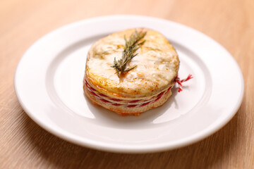 A freshly baked piece of salmon is placed on a plate and sauce is added