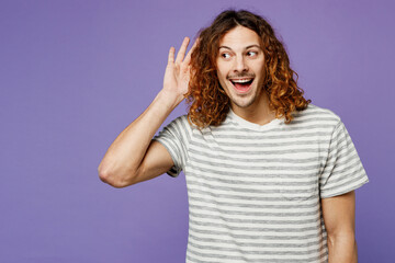 Young curious nosy man he wear grey striped t-shirt casual clothes try to hear you overhear...