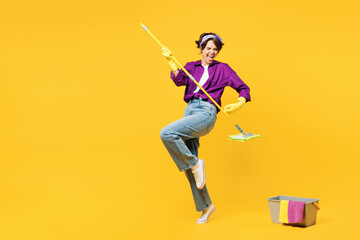 Full body young woman wear purple shirt casual clothes do housework tidy up pov play guitar hold mop bucket water wash floor isolated on plain yellow background studio portrait. Housekeeping concept. - obrazy, fototapety, plakaty