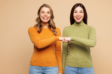 Young smiling happy fun friends two women they wear orange green shirt casual clothes together do...