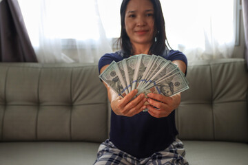 Asian women show a lot of money on hand business concept
