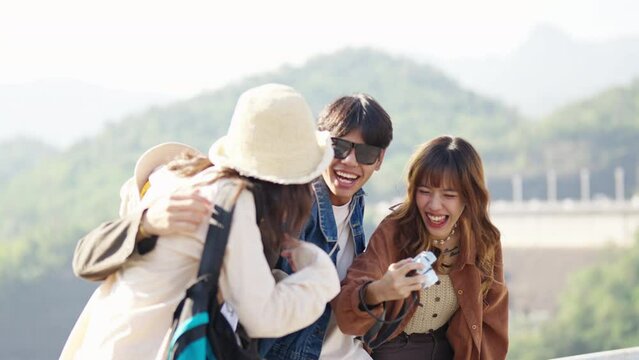 4K Happy young Asian man and woman enjoy and fun outdoor lifestyle road trip travel on summer holiday vacation. Generation z people friends using camera taking picture with beautiful nature together.