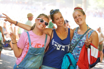 Portrait, friends and peace sign while bonding with smiles at outdoor music festival in Germany. Confident, relaxed and female students with happiness at outdoor event on summer or Spring afternoon