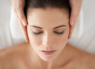 Hands, above and facial massage of woman at spa to relax, peace and calm at luxury resort with masseuse. Top view, therapy and person at salon for face treatment, skincare and beauty for wellness