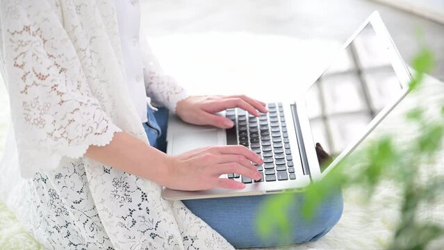 in the hand of a woman using a computer in a room,no-face	