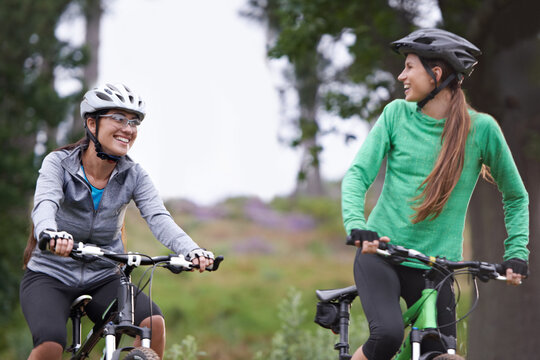 Happy woman, friends and forest with bicycle on field for outdoor cycling, workout or cardio exercise in nature. Female person, athlete or cyclist with smile in fitness for off road training on trail