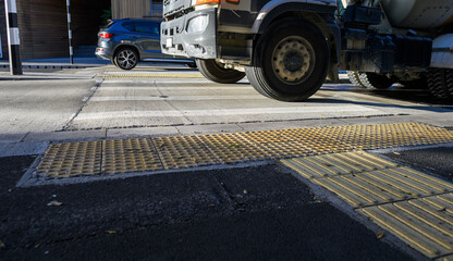 Truck and car driving on raised pedestrian crossing. Auckland.
