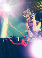 Woman, dj and turntable with headphones for music on stage with lens flare, mixing and gig at rave...