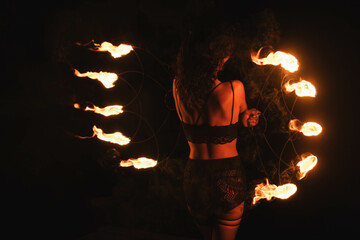 woman standing with fire torch against a sunset in the mountains