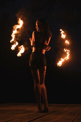 woman standing with fire torch against a sunset in the mountains