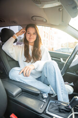 Fototapeta na wymiar Portrait of young woman inside car interior. The car as a place in which a significant part of people lives passes
