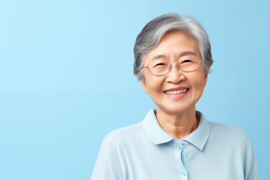 Portrait of older Chinese woman smiling isolated on solid blue background-3.tif