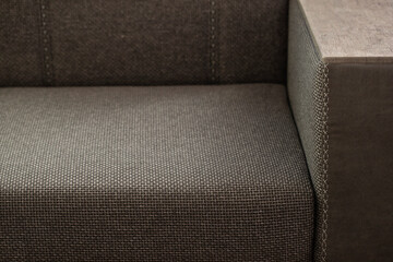 Sofa with decorative stitching. Armrest of upholstered comfortable furniture covered with matting...